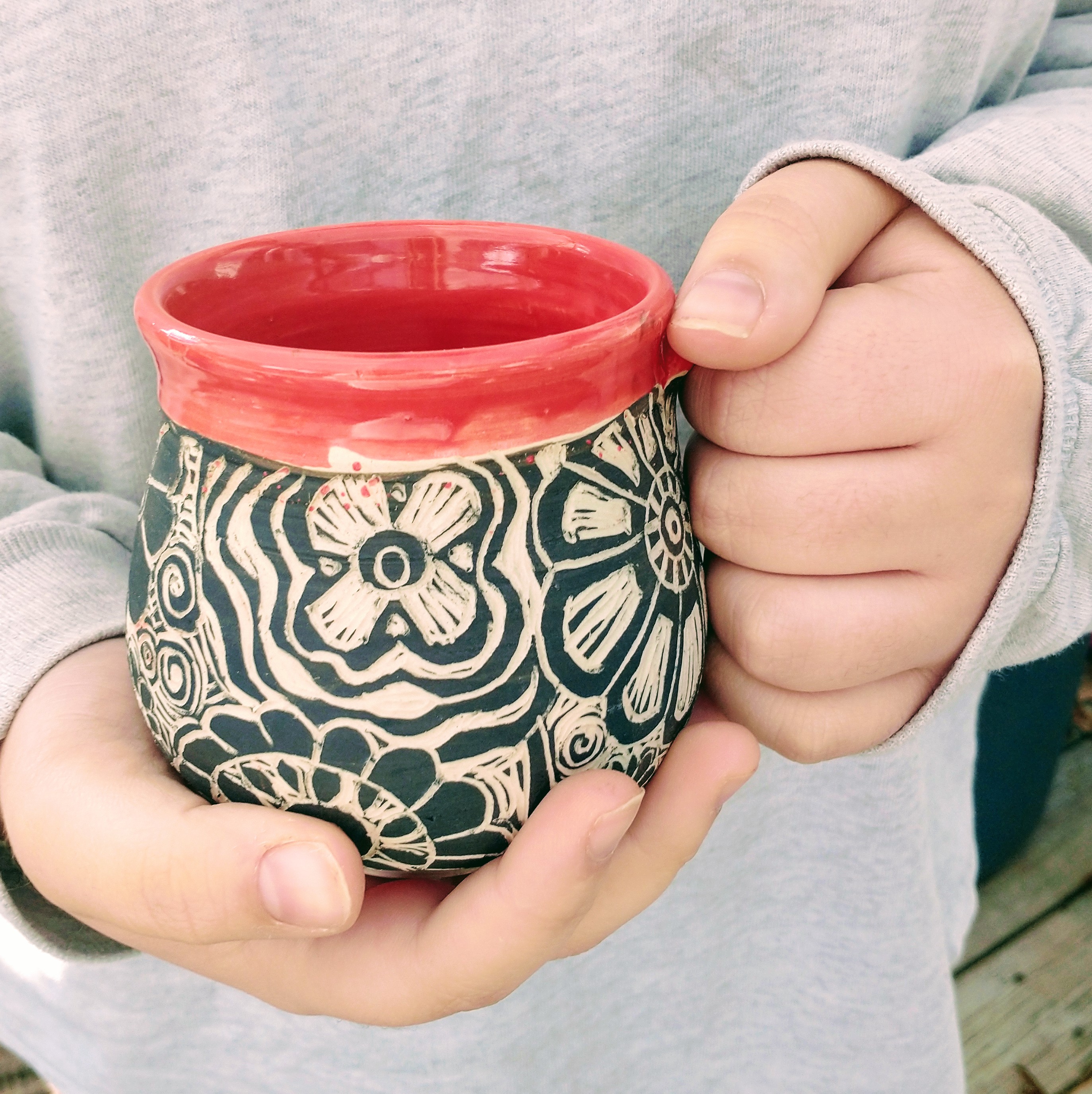 holding a sgraffito mug